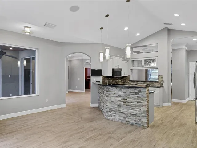 a kitchen with stainless steel appliances kitchen island granite countertop a stove and a sink