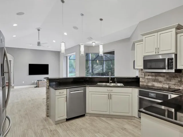 a kitchen with stainless steel appliances a stove sink microwave and cabinets