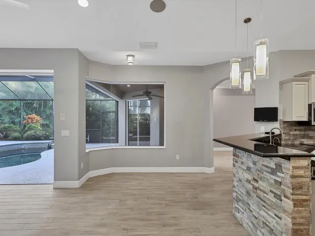 a view of a kitchen with granite countertop a sink and a stove top oven
