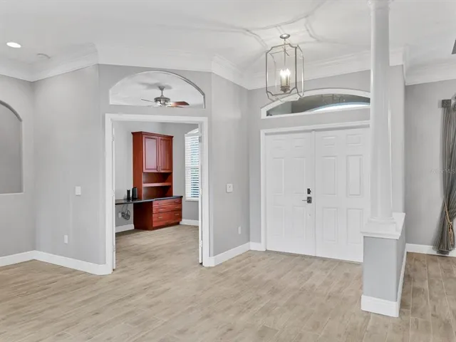a view of a hallway with wooden floor and a kitchen