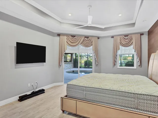 a spacious bedroom with a bed and a flat screen tv