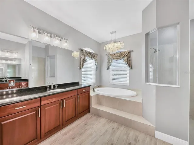 a spacious bathroom with a tub sink and mirror