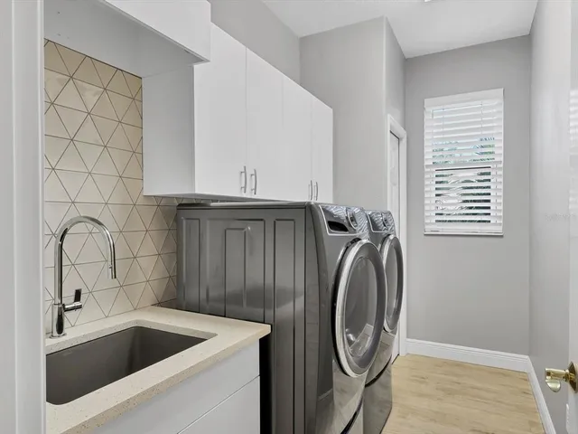 a utility room with sink dryer and washer