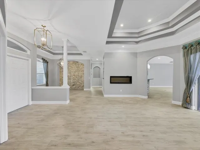 a view of a hallway with wooden floor and chandelier