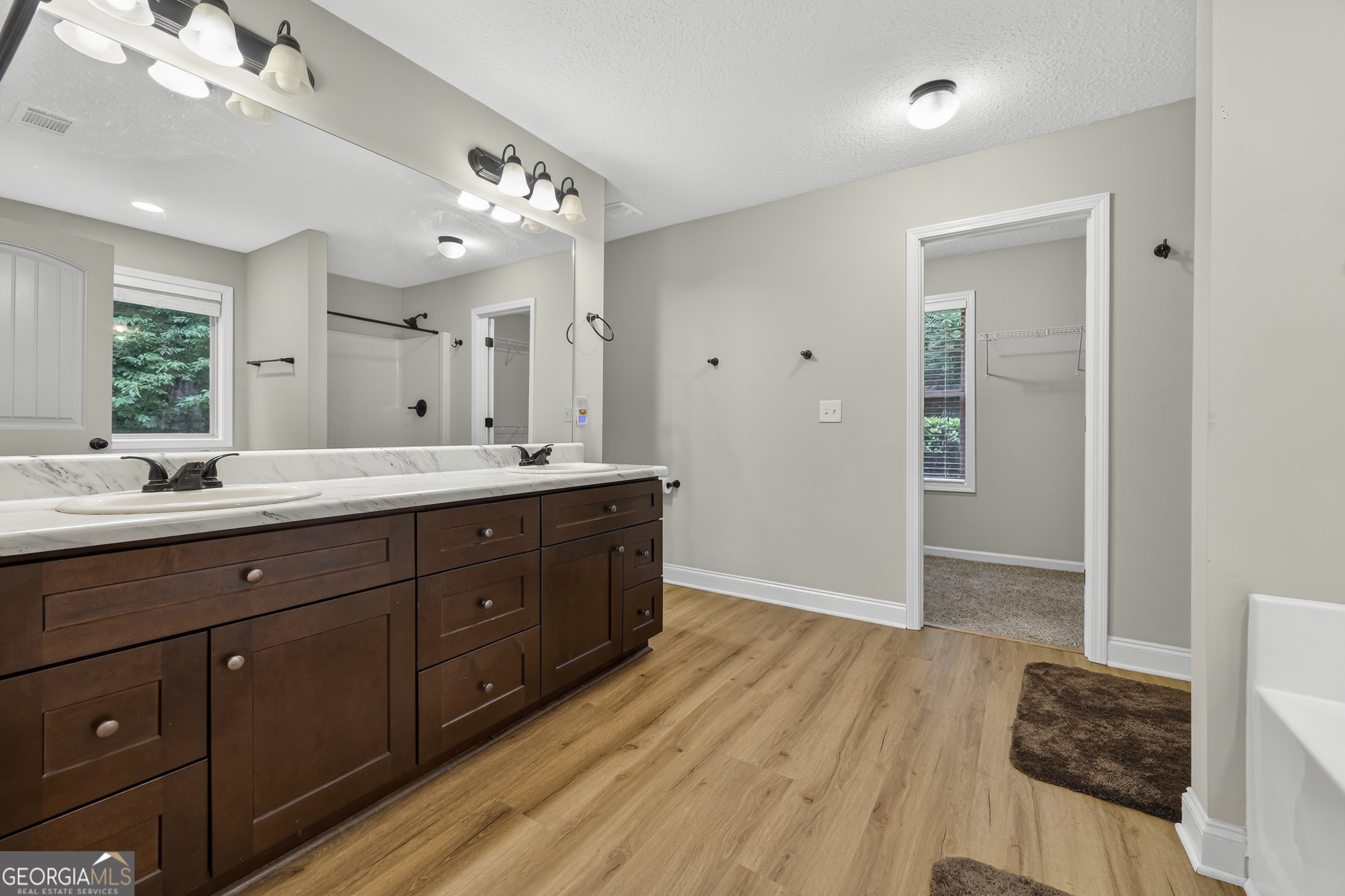 717 Oconee Lane Commerce, GA 30529 - Photo 20 of 57 a spacious bathroom with a double vanity sink a large mirror and shower