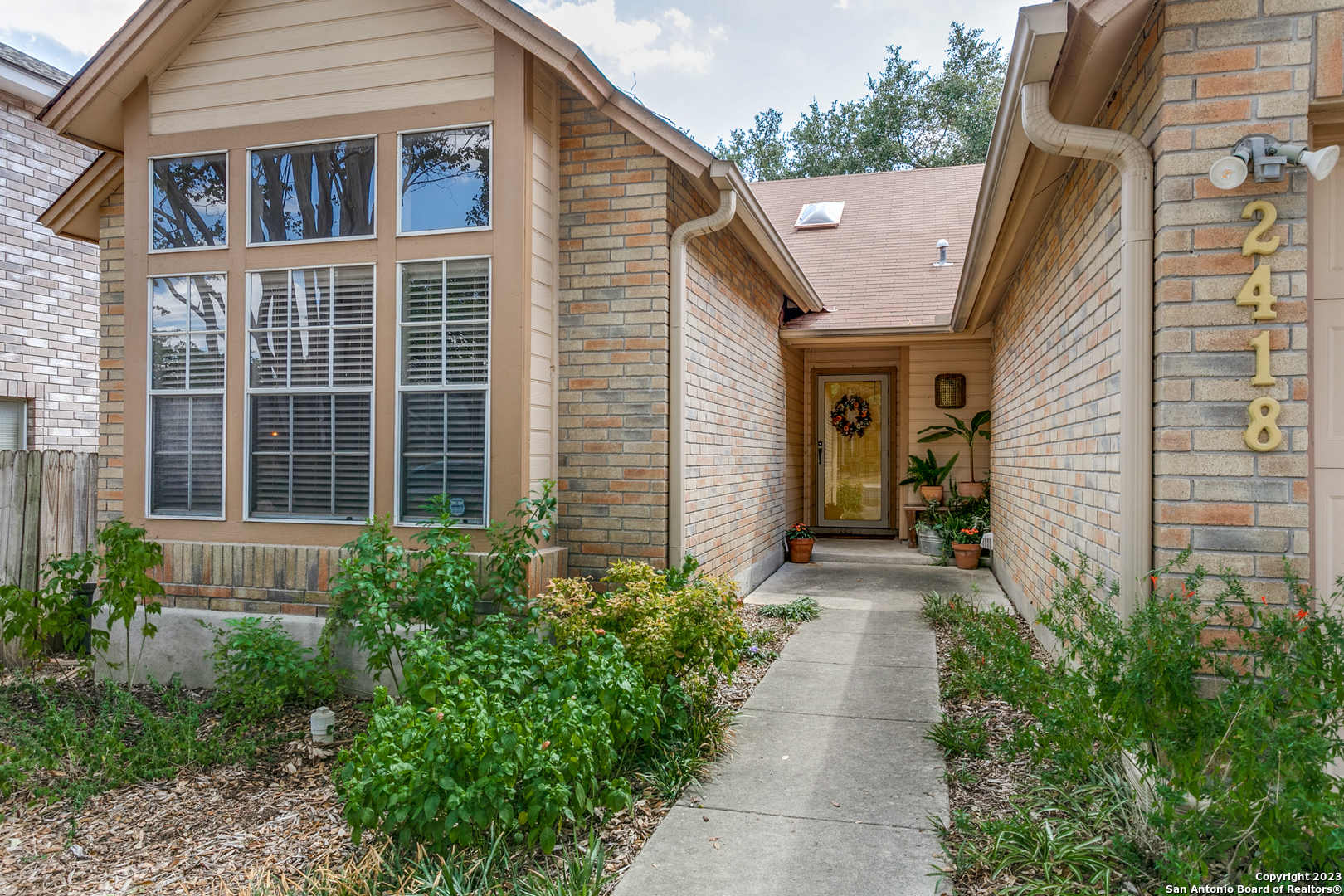a view of a pathway with house and garden