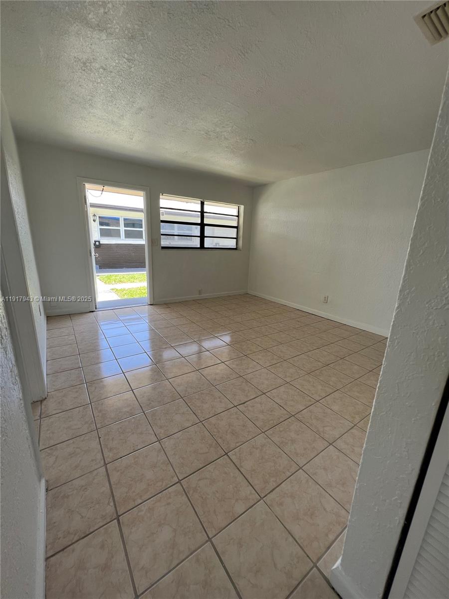 300 Northwest 5th Terrace, Unit 1 Hallandale Beach, FL 33009 - Photo 4 of 13 an empty room with windows