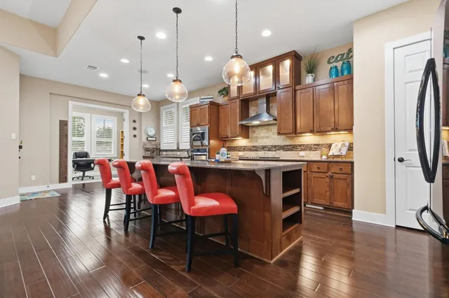 a kitchen with kitchen island granite countertop a sink stove and cabinets