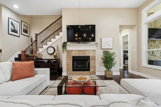 a kitchen with stainless steel appliances granite countertop a stove top oven a refrigerator a dining table and chairs with wooden floor