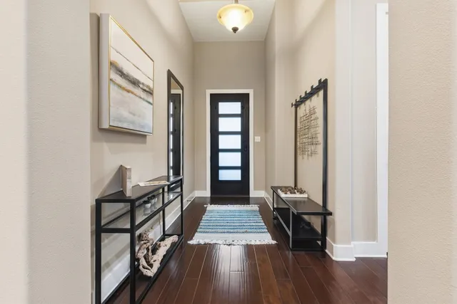 a view of a hallway with wooden floor and stairs