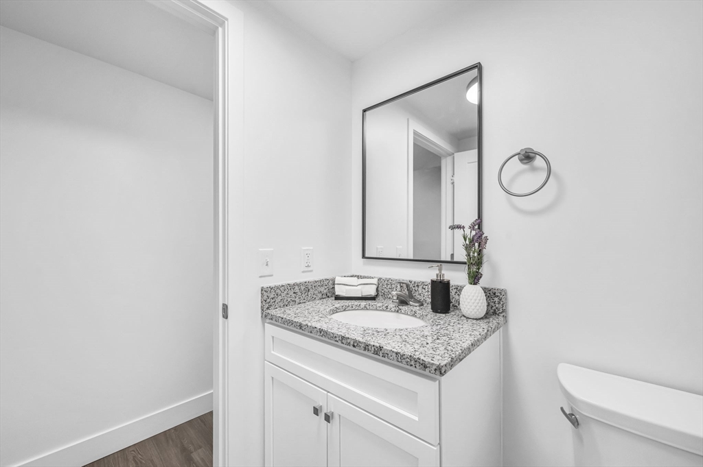 66 Central Street, Unit 404 Springfield, MA 01105 - Photo 13 of 25 a bathroom with a granite countertop sink and a mirror