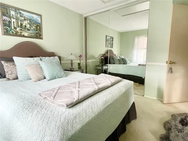 a bedroom with a large bed and a painting on the wall