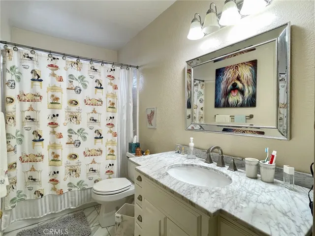 a bathroom with a granite countertop sink and a painting on the wall