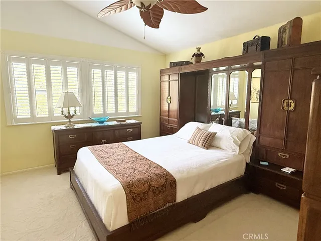 a bedroom with a large bed and wooden floor