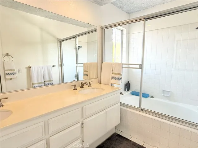 a spacious bathroom with a tub sink and mirror