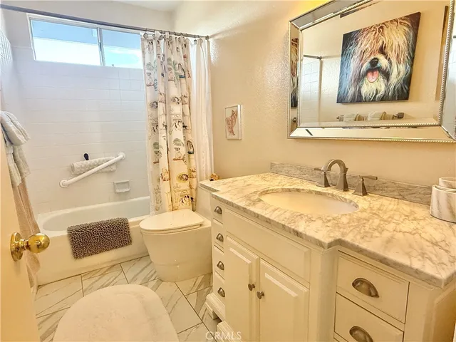 a bathroom with a granite countertop sink mirror vanity and toilet