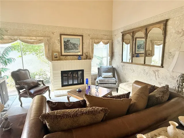 a living room with furniture fireplace and a large window