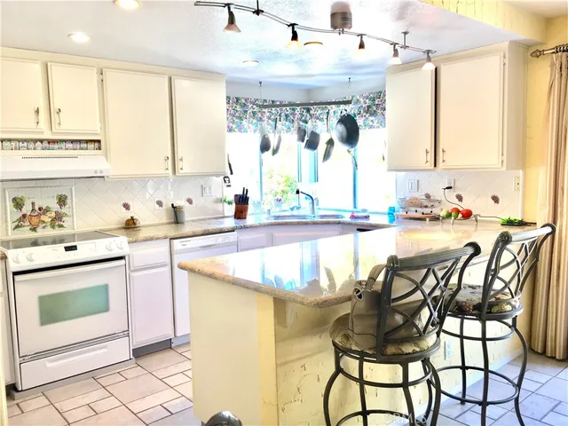 a kitchen with a table chairs sink and cabinets