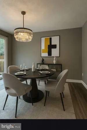 an empty room with wooden floor chandelier and windows
