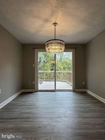 a kitchen with stainless steel appliances granite countertop a refrigerator a sink dishwasher a stove a oven with wooden floor and cabinets next to a window