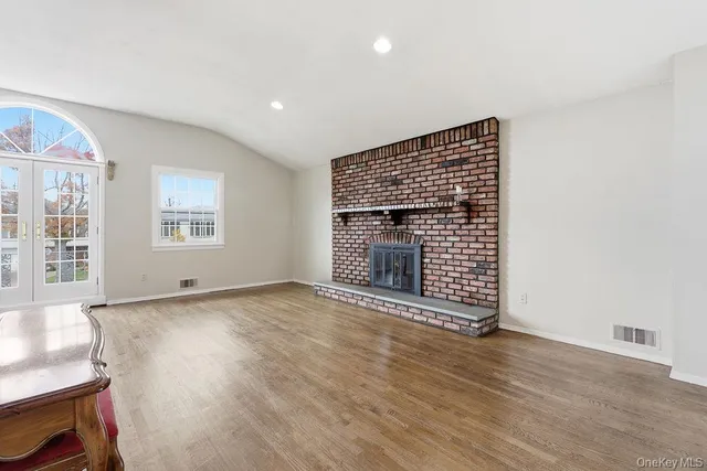 a view of empty room with wooden floor and fireplace