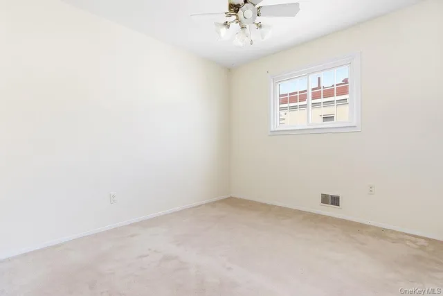 an empty room with a chandelier fan