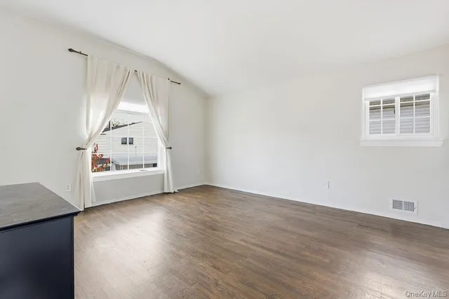 an empty room with wooden floor and white walls