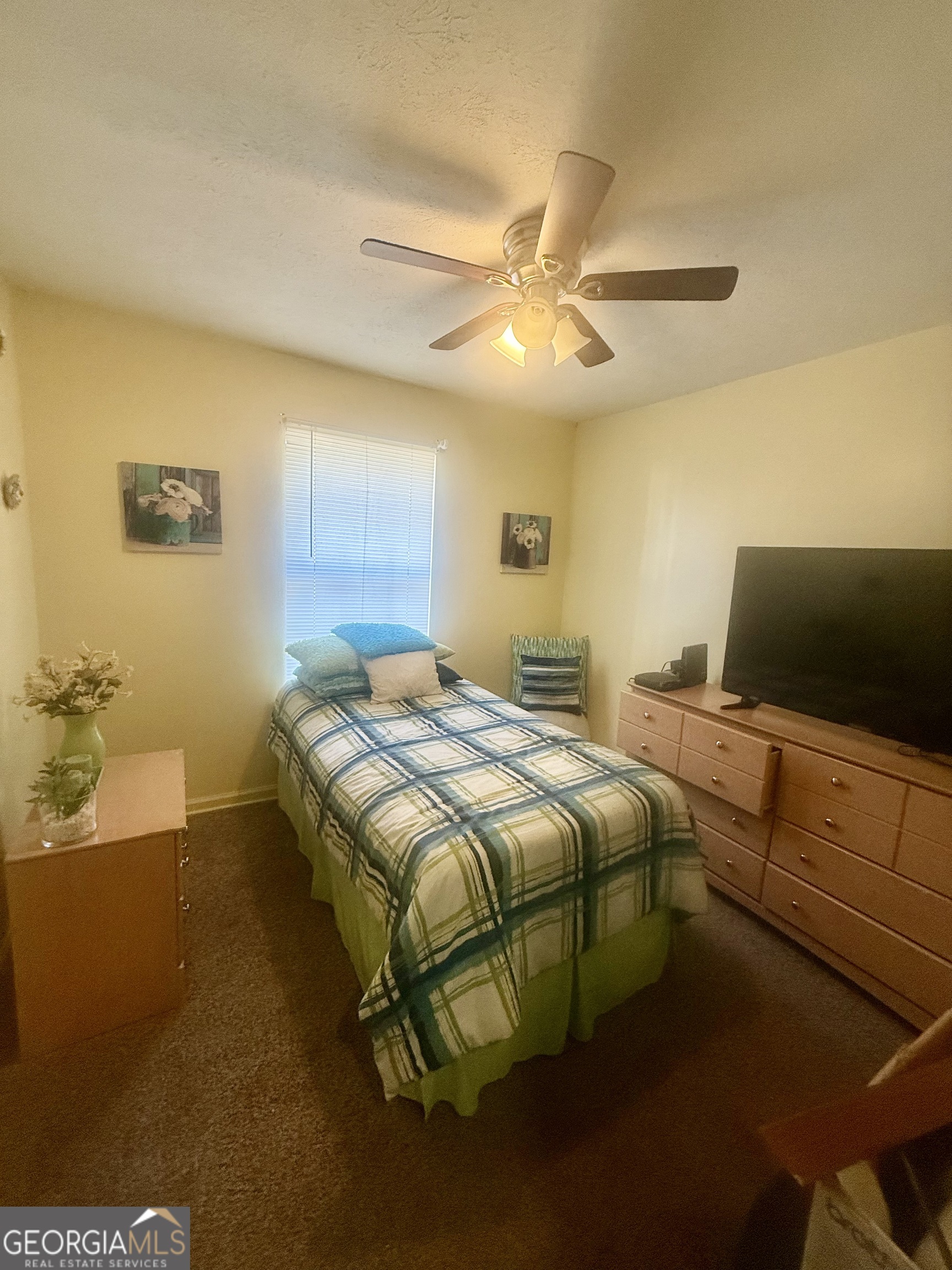 245 West James Circle Hampton, GA 30228 - Photo 11 of 14 a bedroom with a bed and a chandelier