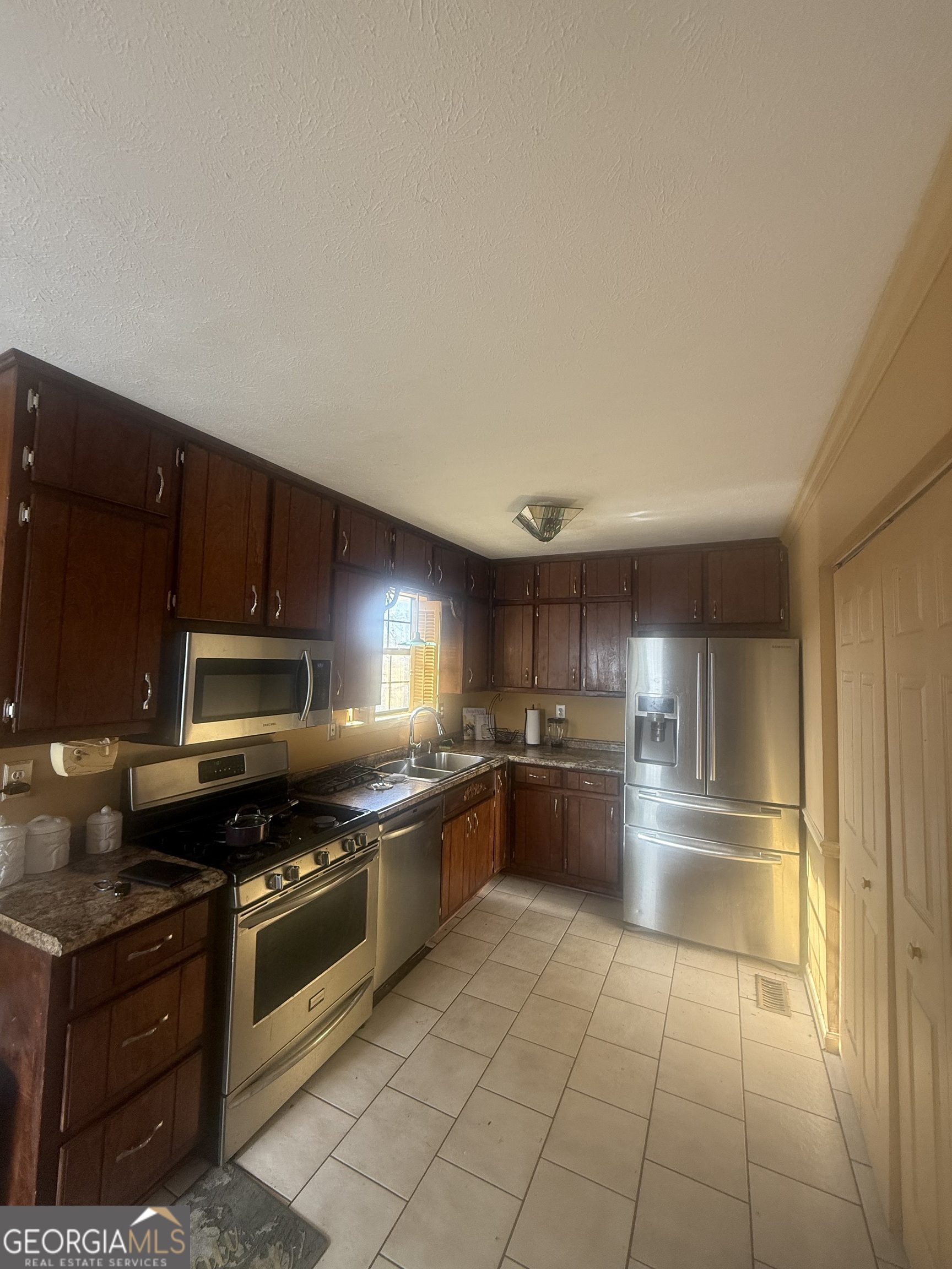 245 West James Circle Hampton, GA 30228 - Photo 5 of 14 a kitchen with stainless steel appliances granite countertop a stove a sink and a refrigerator