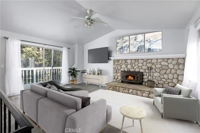 a living room with furniture a large window and a fireplace