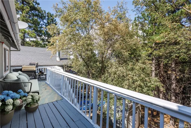 a balcony with wooden floor and outdoor seating