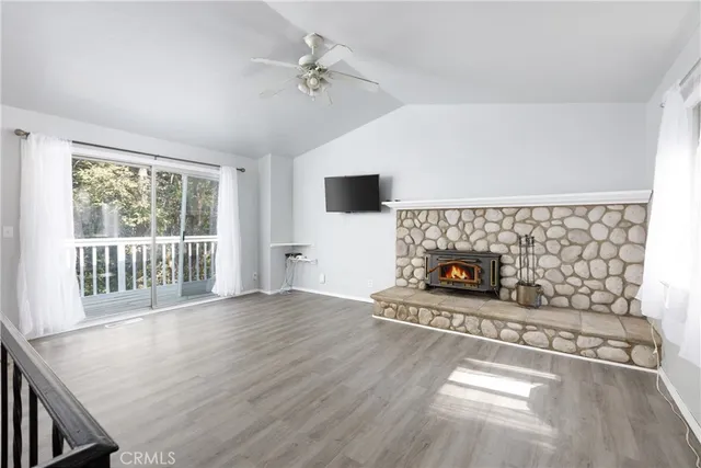 a view of an empty room with a fireplace and a window