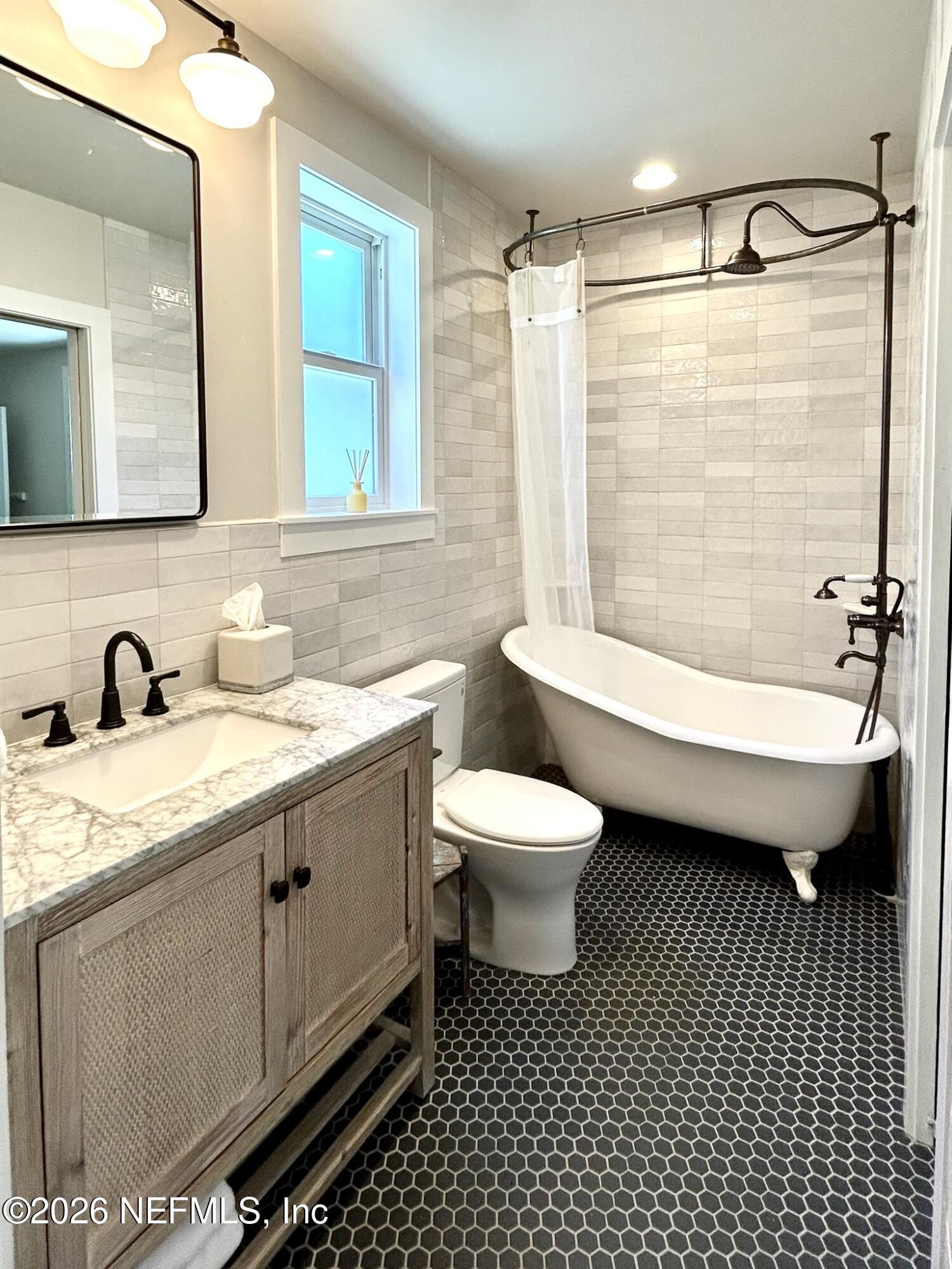1011 Inwood Terrace Jacksonville, FL 32207 - Photo 24 of 56 a bathroom with a granite countertop sink mirror vanity and toilet