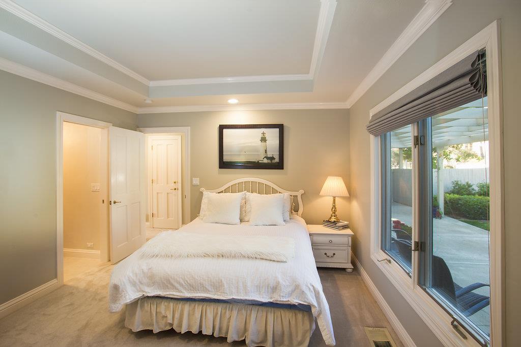 1003 Rodeo Road Pebble Beach, CA 93953 - Photo 16 of 24 a bedroom with a bed and large mirror