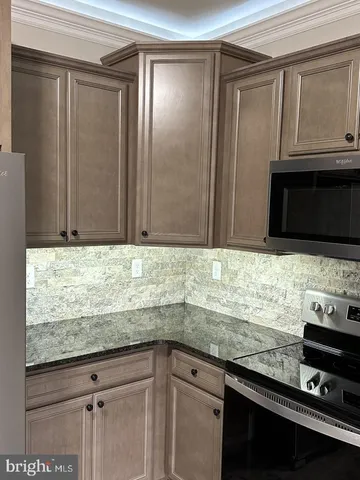 a kitchen with granite countertop cabinets sink and stainless steel appliances