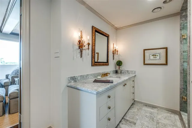 a en suite bathroom with a granite countertop sink and a mirror