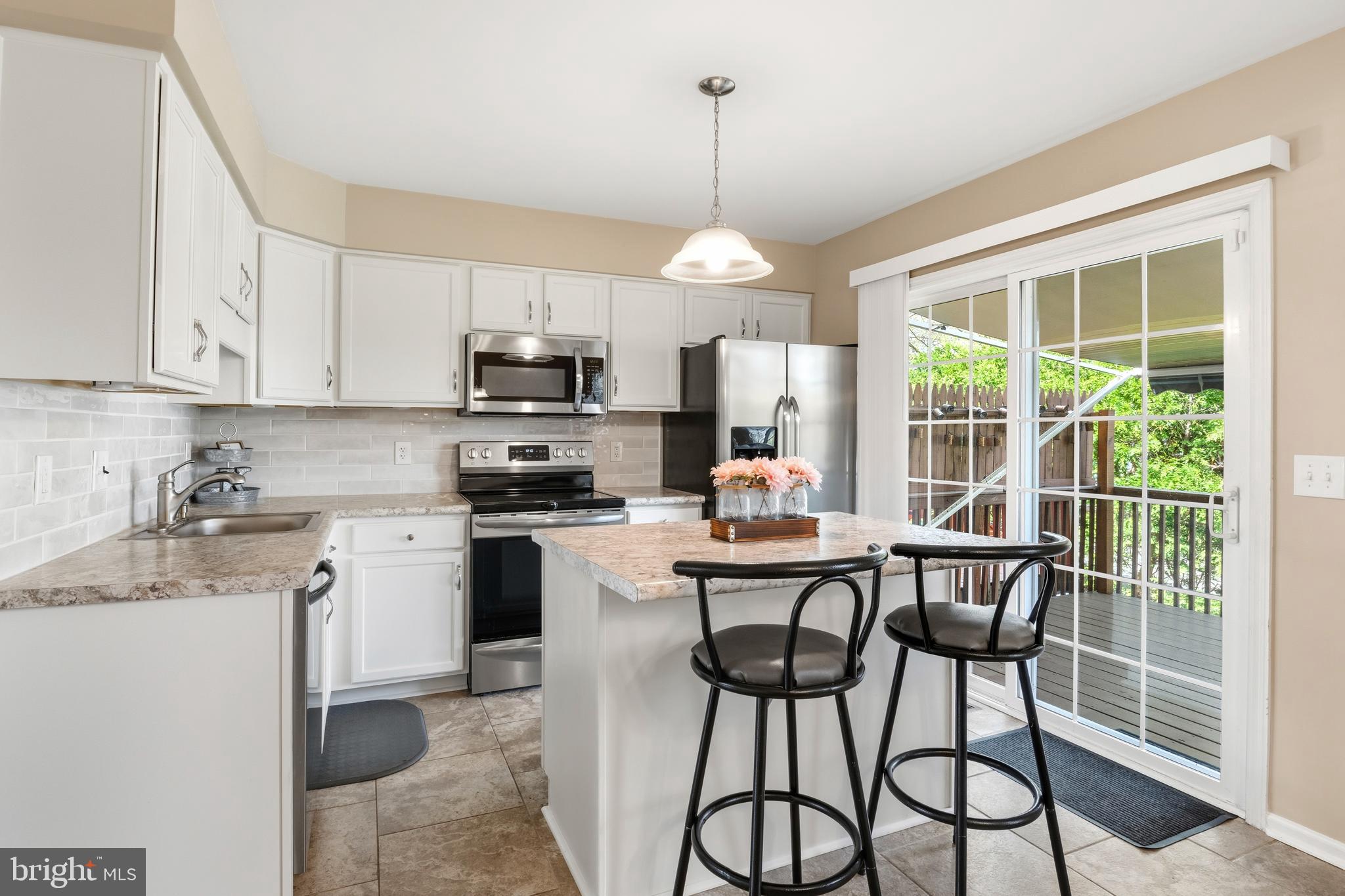 129 Catherine Street, Unit 3 Telford, PA 18969 - Photo 8 of 34 a kitchen with stainless steel appliances granite countertop a stove a refrigerator a sink a island with a dining table and chairs