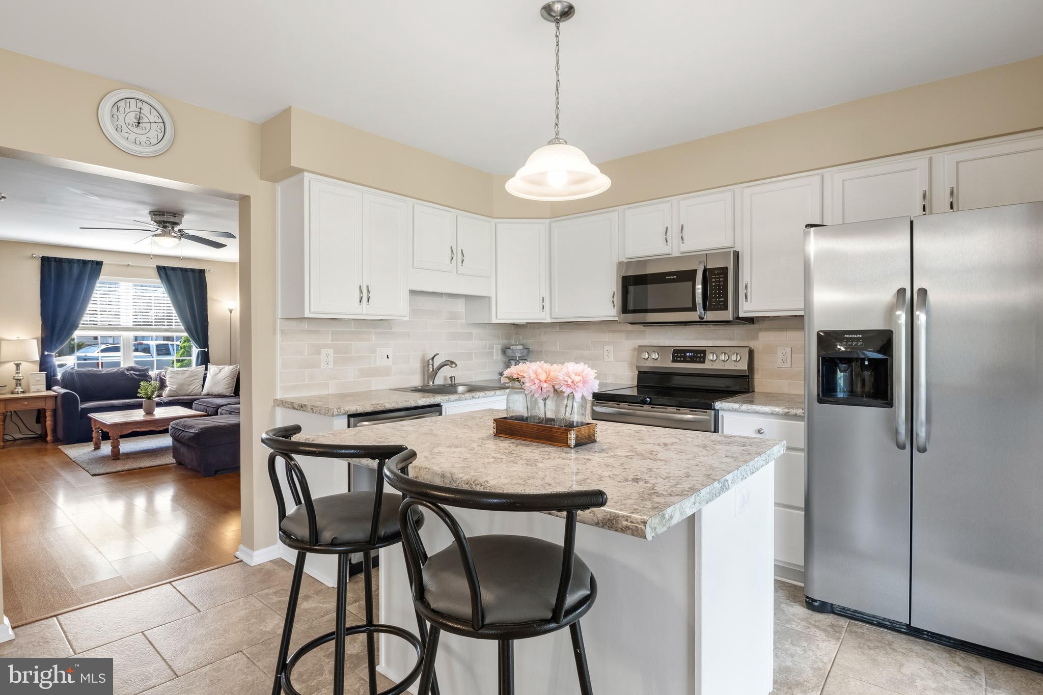 129 Catherine Street, Unit 3 Telford, PA 18969 - Photo 9 of 34 a kitchen with stainless steel appliances granite countertop a stove a refrigerator a kitchen island a table and chairs