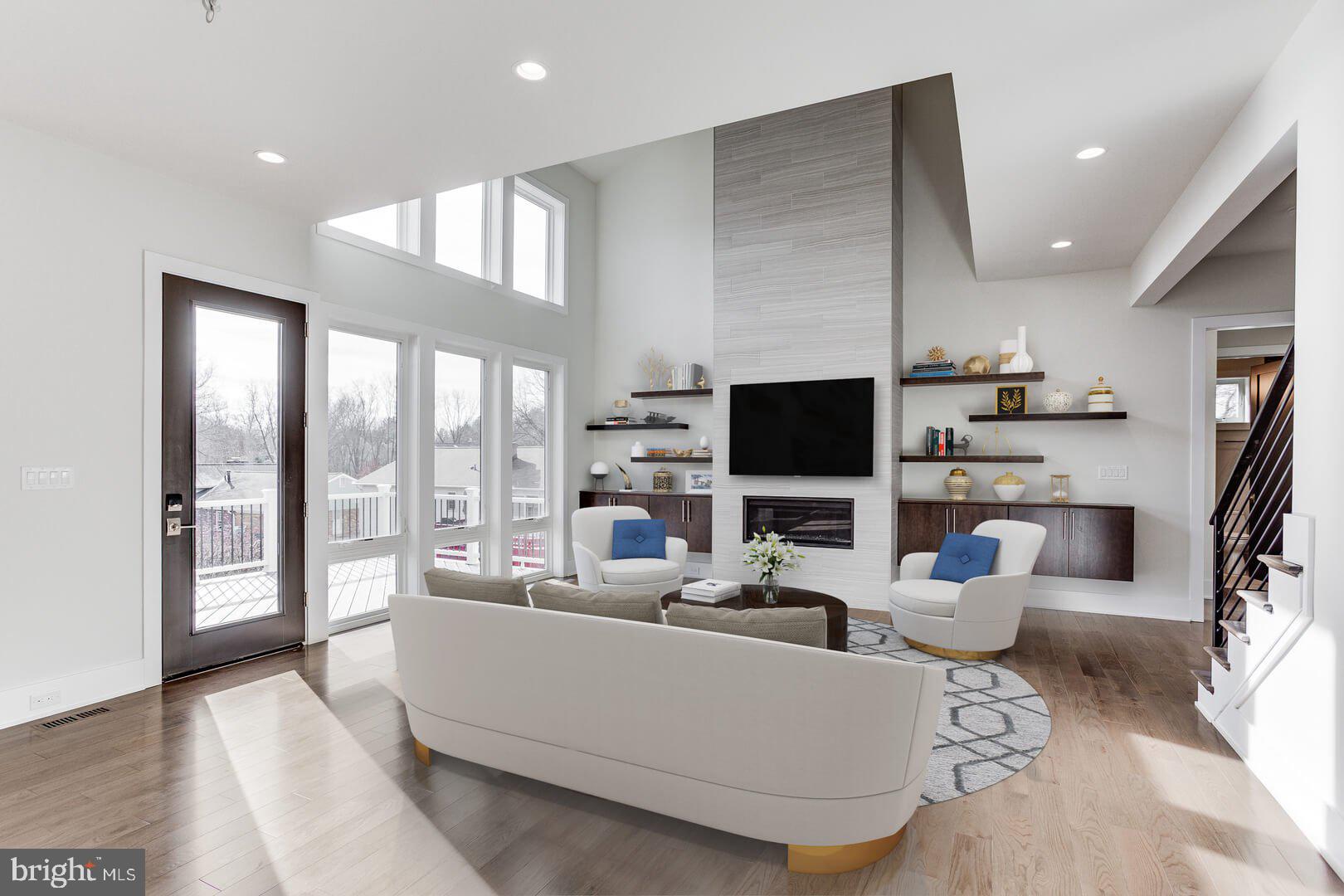 2925 West Ox Road Herndon, VA 20171 - Photo 26 of 38 a living room with furniture a flat screen tv and a floor to ceiling window