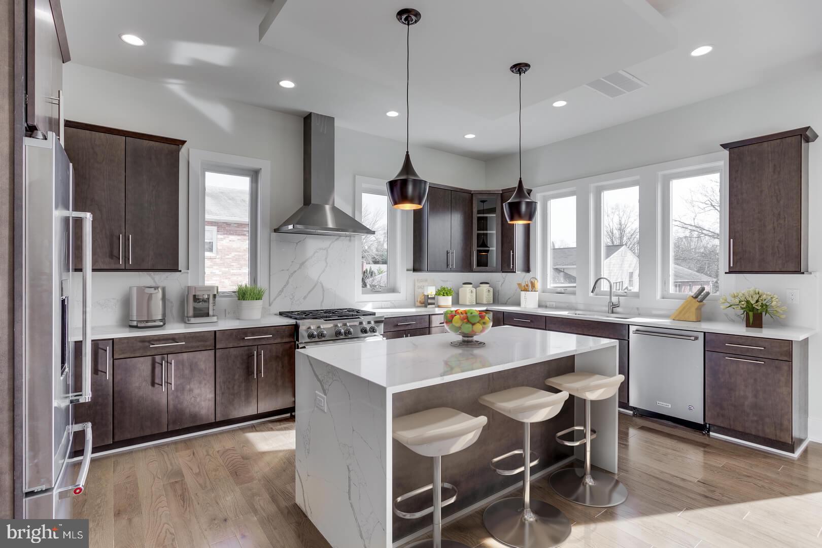 2925 West Ox Road Herndon, VA 20171 - Photo 29 of 38 a kitchen with a stove a sink a kitchen island with wooden cabinets and glass windows