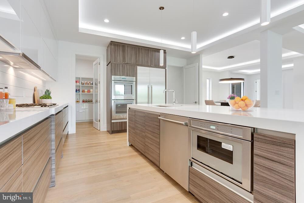 2925 West Ox Road Herndon, VA 20171 - Photo 4 of 38 a large white kitchen with stainless steel appliances