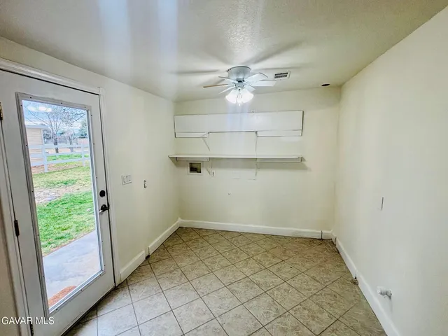an empty room with a ceiling fan and a window