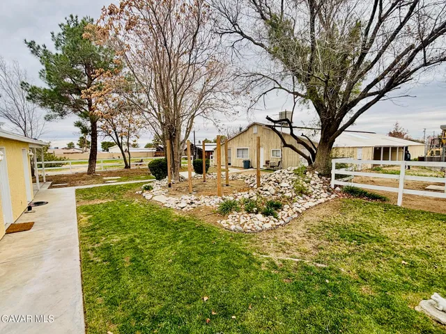 a view of a yard with yellow house