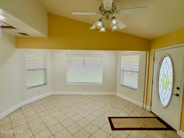 a view of a livingroom with a chandelier fan and a window