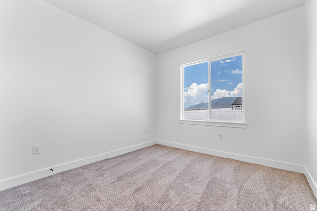 2362 1400 West, Unit 14 Perry, UT 84302 - Photo 10 of 22 Interior room with neutral carpet, white walls, and a large window
