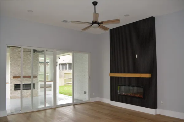 a view of a hallway with wooden floor and a fireplace