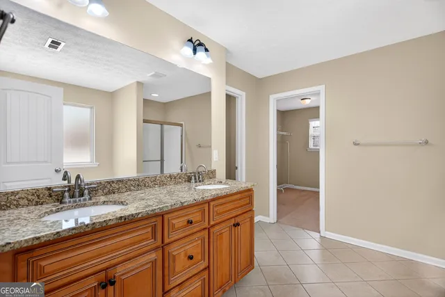 a spacious bathroom with a granite countertop sink and a mirror