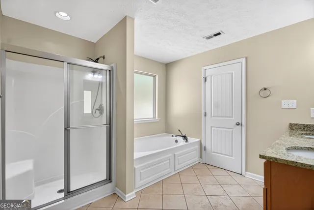 a bathroom with a tub shower and sink