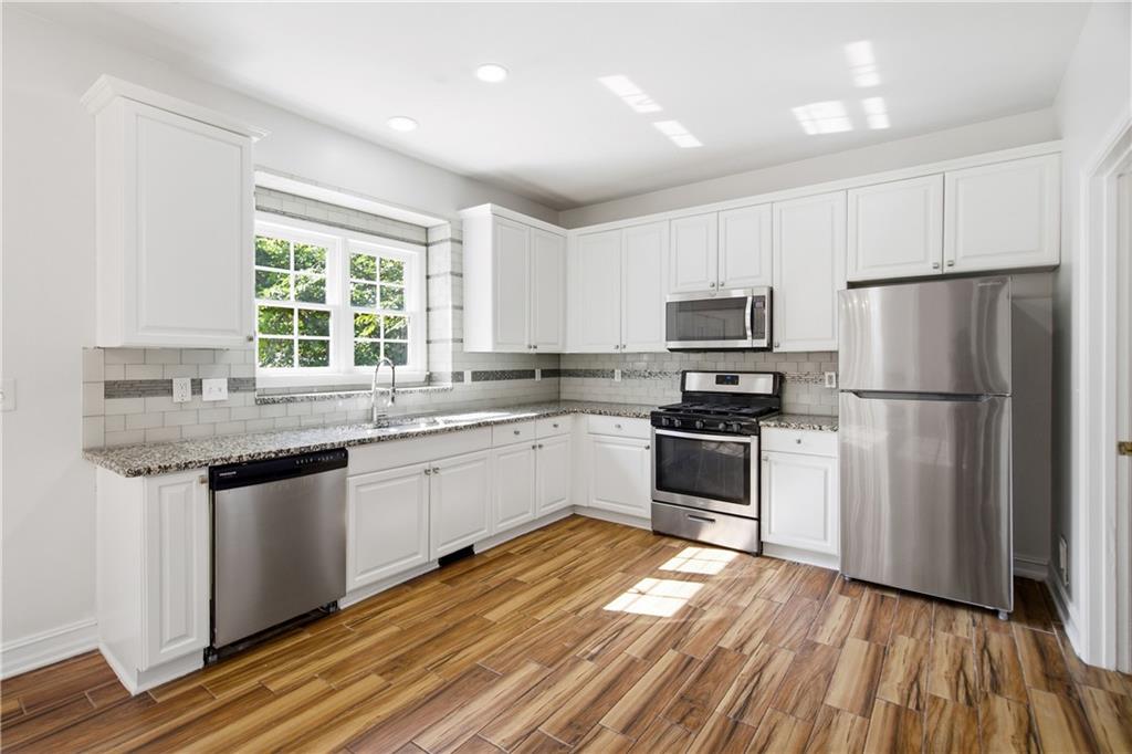 110 Mayes Farm Road Northwest Marietta, GA 30064 - Photo 17 of 49 a kitchen with granite countertop stainless steel appliances a sink cabinets and a window