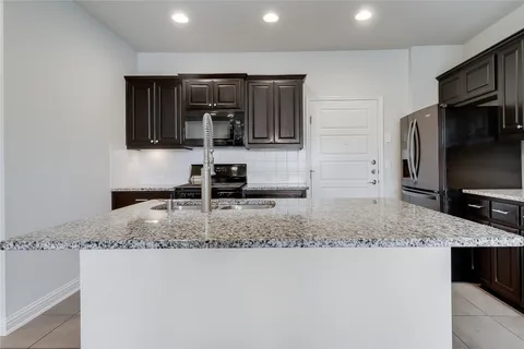 a kitchen with stainless steel appliances a sink a stove a microwave and cabinets